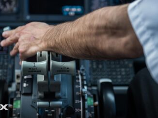 Mano de piloto ajustando controles en la cabina de un avión comercial, representando la extensión de la edad jubilatoria en Argentina.