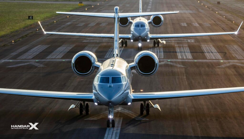 Gulfstream celebra 300 entregas en la familia G500 y G600 Dos jets ejecutivos Gulfstream G500 y G600 en la pista al amanecer, representando la excelencia en aviación de lujo y tecnología avanzada.