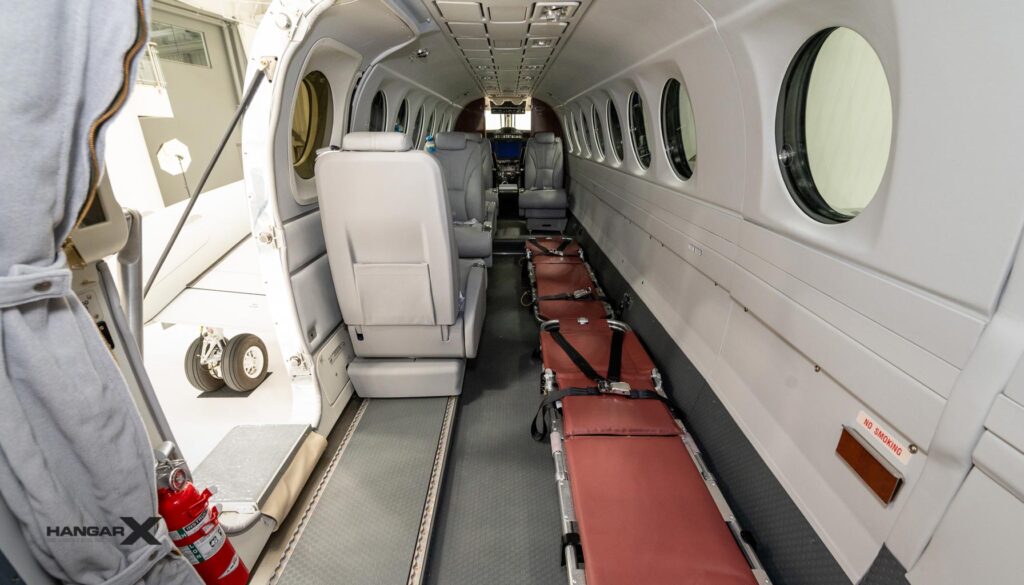 Interior del Beechcraft King Air 360CHW configurado para evacuaciones aeromédicas con camillas y asientos para personal médico.