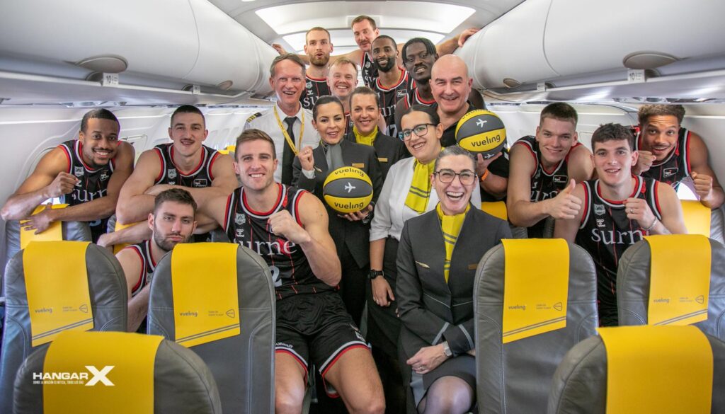 Vueling renueva su patrocinio con el Bilbao Basket para 2024/25 Jugadores del Bilbao Basket junto a la tripulación de Vueling celebrando la renovación del patrocinio para la temporada 2024/25 dentro de un avión de la aerolínea.