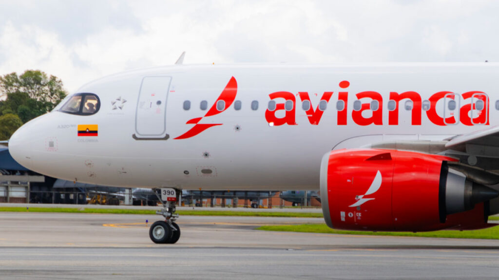 Avianca anuncia nuevas rutas internacionales desde Colombia y Costa Rica para 2025 Primer plano de un avión Airbus A320 de Avianca en pista, mostrando su diseño característico con el logotipo de la aerolínea y la bandera de Colombia.