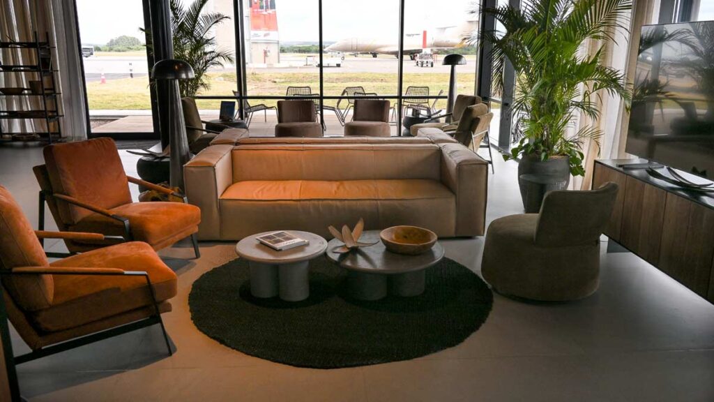 Lounge de la nueva terminal de aviación privada del Aeropuerto de Punta del Este, con mobiliario moderno y vistas a la plataforma.