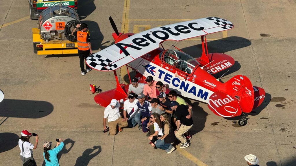 Aeronave acrobática Pitts S2-B de Jorge Malatini en festival aéreo con asistentes posando en la pista.