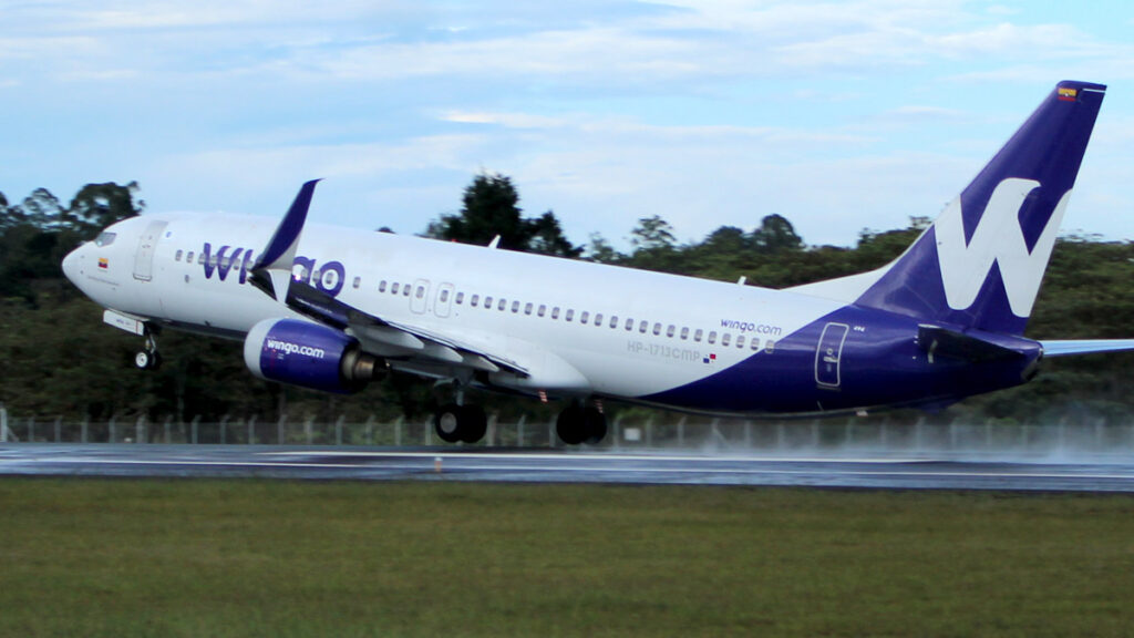 Wingo crecerá en 2025 con más vuelos y mayor presencia en Colombia Avión Boeing 737-800 de la aerolínea Wingo despegando en pista mojada, con fondo natural, como parte de la expansión de la aerolínea en 2025.
