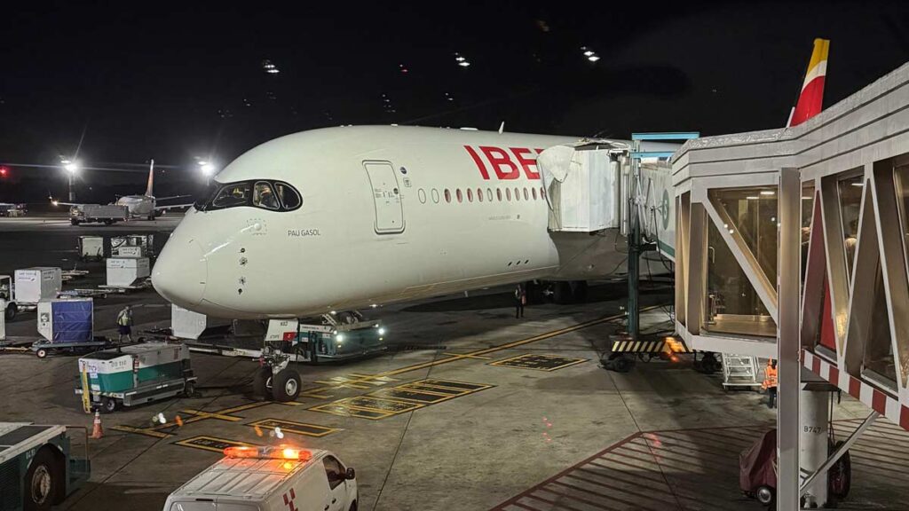 Iberia anuncia más vuelos a Italia, Francia y Austria para el invierno 2025 Avión Airbus A350 de Iberia en manga de embarque durante operación nocturna