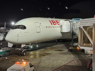 Avión Airbus A350 de Iberia en manga de embarque durante operación nocturna
