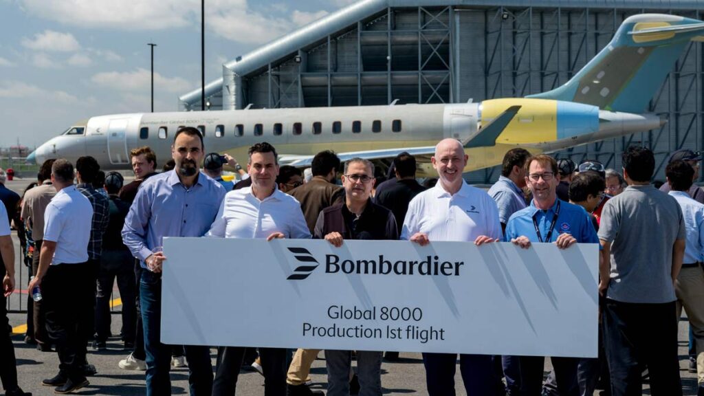 Primer vuelo de producción del Bombardier Global 8000 con equipo celebrando frente a la aeronave