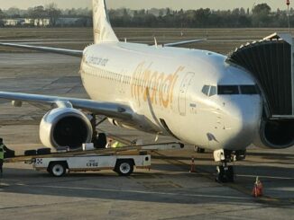 Avión Boeing 737-800 de la aerolínea Low Cost Flybondi en manga de embarque durante operación en aeropuerto argentino