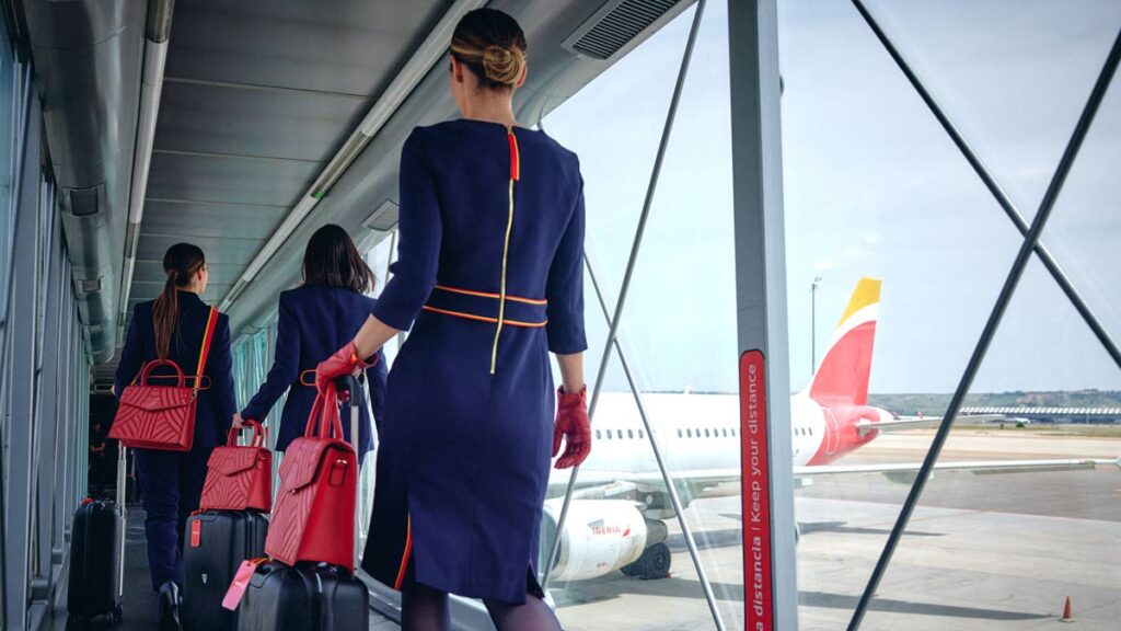 Iberia y sindicatos alcanzan un preacuerdo con mejoras salariales y laborales Tripulación de Iberia caminando por el finger hacia el avión en aeropuerto