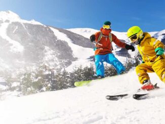 Personas esquiando en la nieve con montañas nevadas al fondo en Bariloche, durante la temporada de invierno
