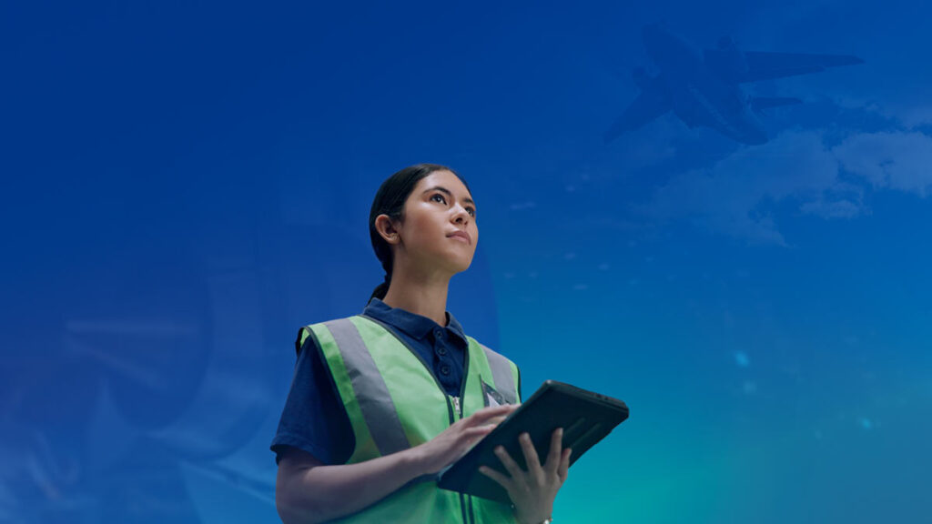 Última semana para inscribirse en la Maestría en Ingeniería Aeronáutica de Embraer e ITA Joven ingeniera en formación observa un avión, representando la Maestría en Ingeniería Aeronáutica de Embraer e ITA en Brasil