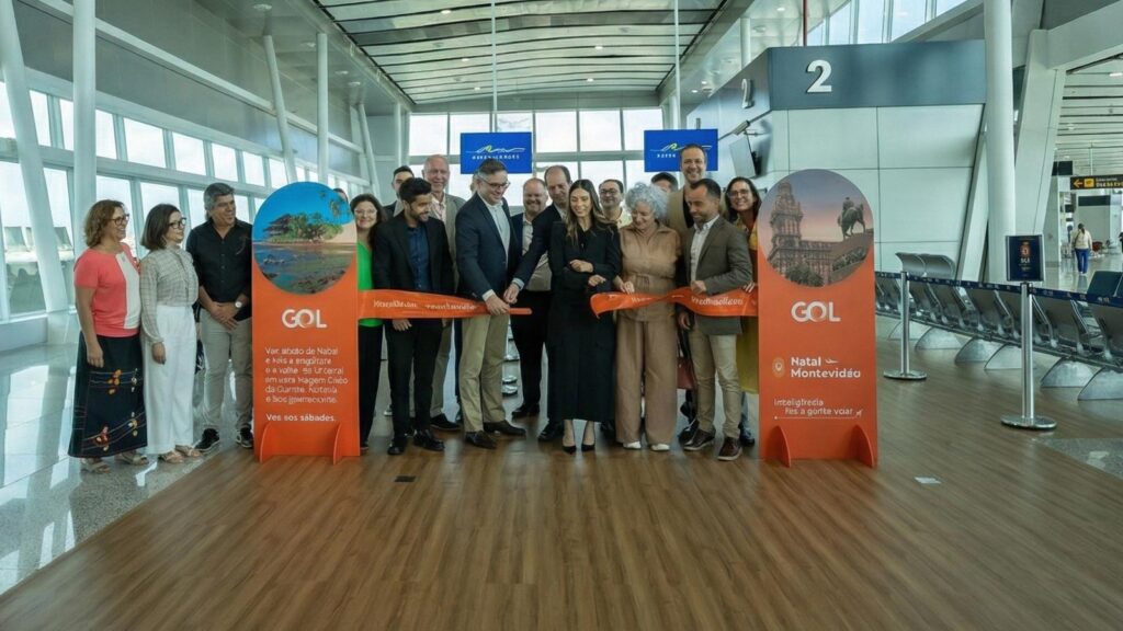 Conexión directa al Nordeste de Brasil: el plan de expansión de GOL en Uruguay Grupo de personas en una ceremonia de corte de cinta dentro de una terminal de aeropuerto, flanqueados por pancartas de GOL con el texto 'Natal - Montevideo'