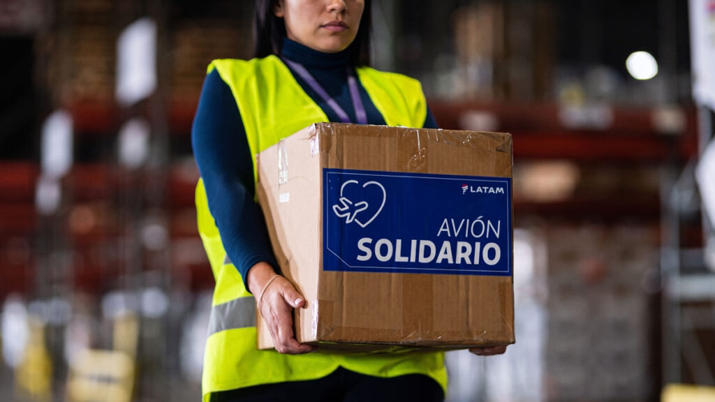 LATAM expande su programa Avión Solidario en Chile con cinco nuevas alianzas corporativas Avión Solidario LATAM Chile: Operaria logística sostiene una caja con la etiqueta del programa de asistencia humanitaria de la aerolínea