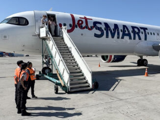 Airbus A321neo de JetSMART estacionado en plataforma de Aeroparque durante el día, con pasajeros utilizando la escalera móvil delantera bajo la supervisión del personal de tierra.