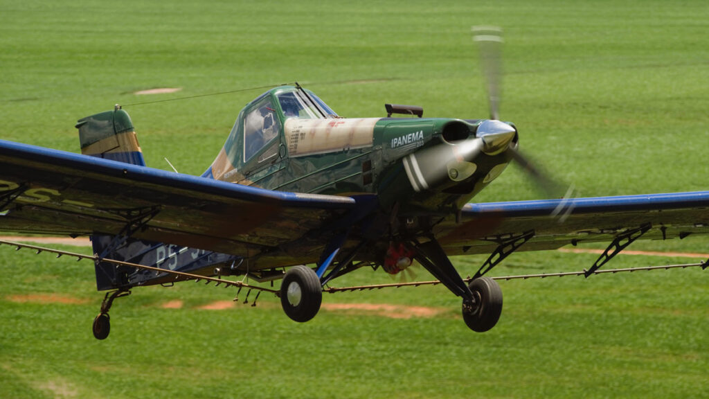 Embraer presentará su avión agrícola Ipanema 203 en la Exposición Rural de Buenos Aires Avión agrícola Embraer Ipanema 203 en pleno vuelo a baja altura sobre un campo, mostrando el sistema de barras de pulverización en operación.