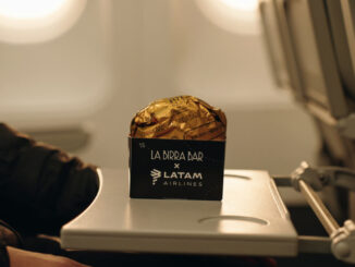 Empaque de la hamburguesa Golden de La Birra Bar servida sobre la mesa rebatible en la cabina de un avión de LATAM Airlines.
