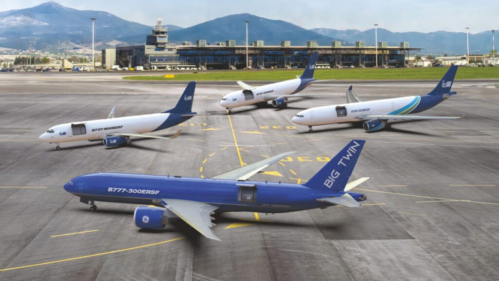 Merlin e IAI desarrollarán aviones de carga autónomos impulsados por IA Cuatro aviones cargueros convertidos por Israel Aerospace Industries (IAI) estacionados en la plataforma de un aeropuerto, incluyendo los modelos B777-300ERSF, B737-800BDSF, B767-300BDSF y A330-300BDSF con sus compuertas abiertas