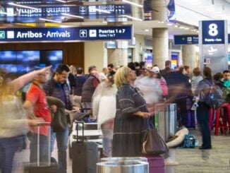 Pasajeros transitando por la terminal del Aeroparque Jorge Newbery frente a las pantallas de información de vuelos tras su reapertura