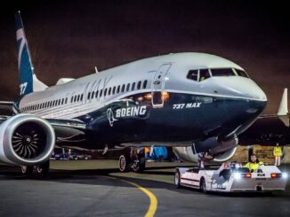 Fotografía nocturna de un avión comercial Boeing 737 MAX 7 siendo remolcado en la plataforma de un aeropuerto