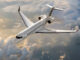 Jet corporativo Bombardier Global 8000 en pleno vuelo sobre un paisaje nuboso al atardecer