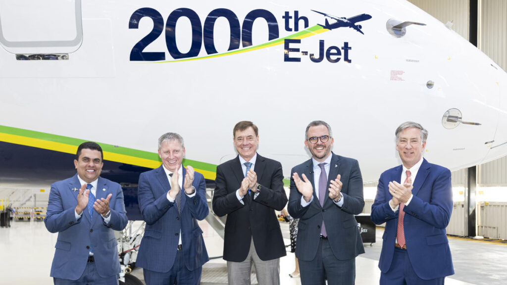 Entrega histórica: Azul recibe el Embraer E-Jet número 2.000 Ejecutivos de Embraer y Azul Linhas Aéreas celebrando frente al avión E195-E2 conmemorativo durante la ceremonia de entrega.