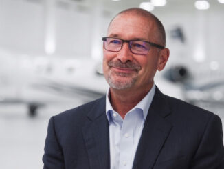 Retrato de Brian Rohloff, nuevo Presidente y CEO de Textron Aviation, posando en un hangar con una aeronave ejecutiva de fondo