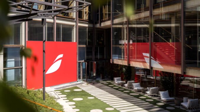 Patio interior del Colegio Oficial de Arquitectos de Madrid intervenido con un gran panel rojo y el logotipo del Espacio Iberia.