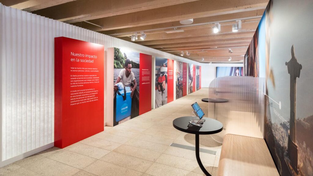 Espacio Iberia en Madrid: cómo es la nueva experiencia inmersiva de la aerolínea Pasillo de exhibición e interacción dentro del Espacio Iberia en Madrid, equipado con paneles informativos y tablets.