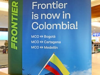 Cartel promocional de Frontier Airlines en el aeropuerto de Orlando anunciando sus nuevas rutas hacia Colombia.