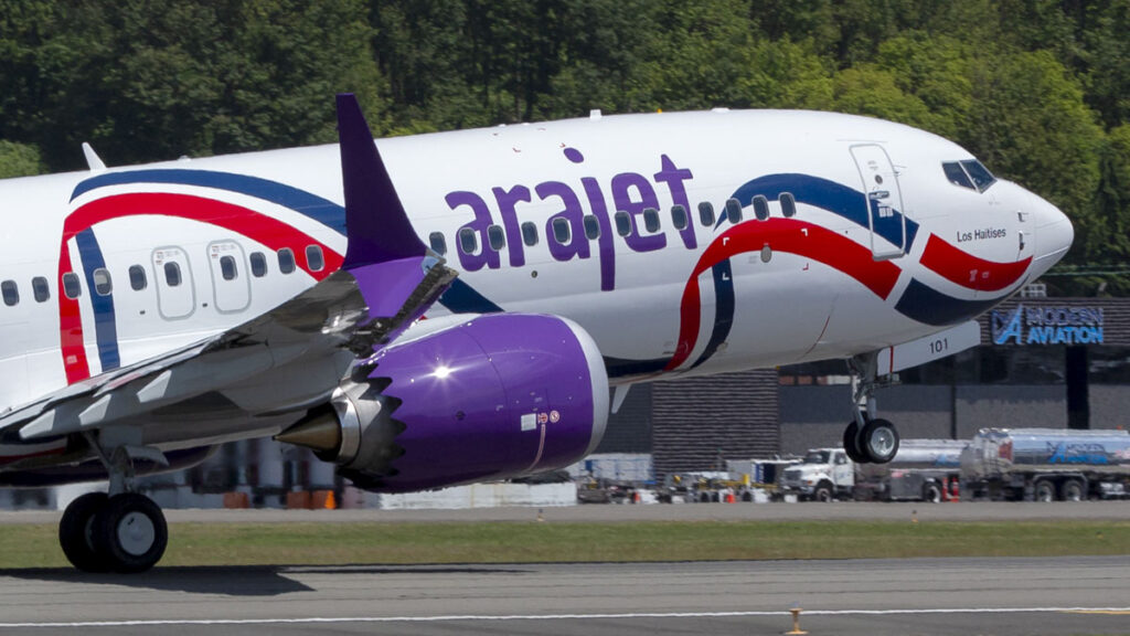 Conectividad regional: Arajet consolida su expansión en México con crecimiento histórico Avión Boeing 737 MAX de Arajet operando en pista, mostrando su característico fuselaje blanco con líneas rojas y azules y motores violetas.