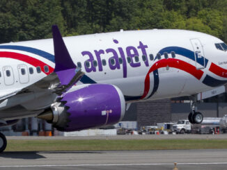 Avión Boeing 737 MAX de Arajet operando en pista, mostrando su característico fuselaje blanco con líneas rojas y azules y motores violetas.