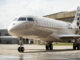 Jet ejecutivo Bombardier Global 8000 estacionado en la plataforma de un complejo industrial, ilustrando la expansión de infraestructura técnica del fabricante en Estados Unidos.