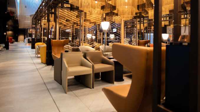 Interior del LATAM Lounge Santiago en el Aeropuerto Arturo Merino Benítez, con sillones de diseño y luminarias cálidas, destacada como la mejor sala VIP de Sudamérica.
