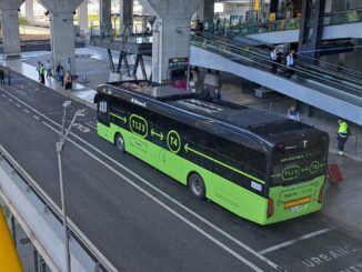 Vista elevada de un nuevo autobús 100% eléctrico de Monbus estacionado en la plataforma exterior del Aeropuerto Madrid-Barajas.